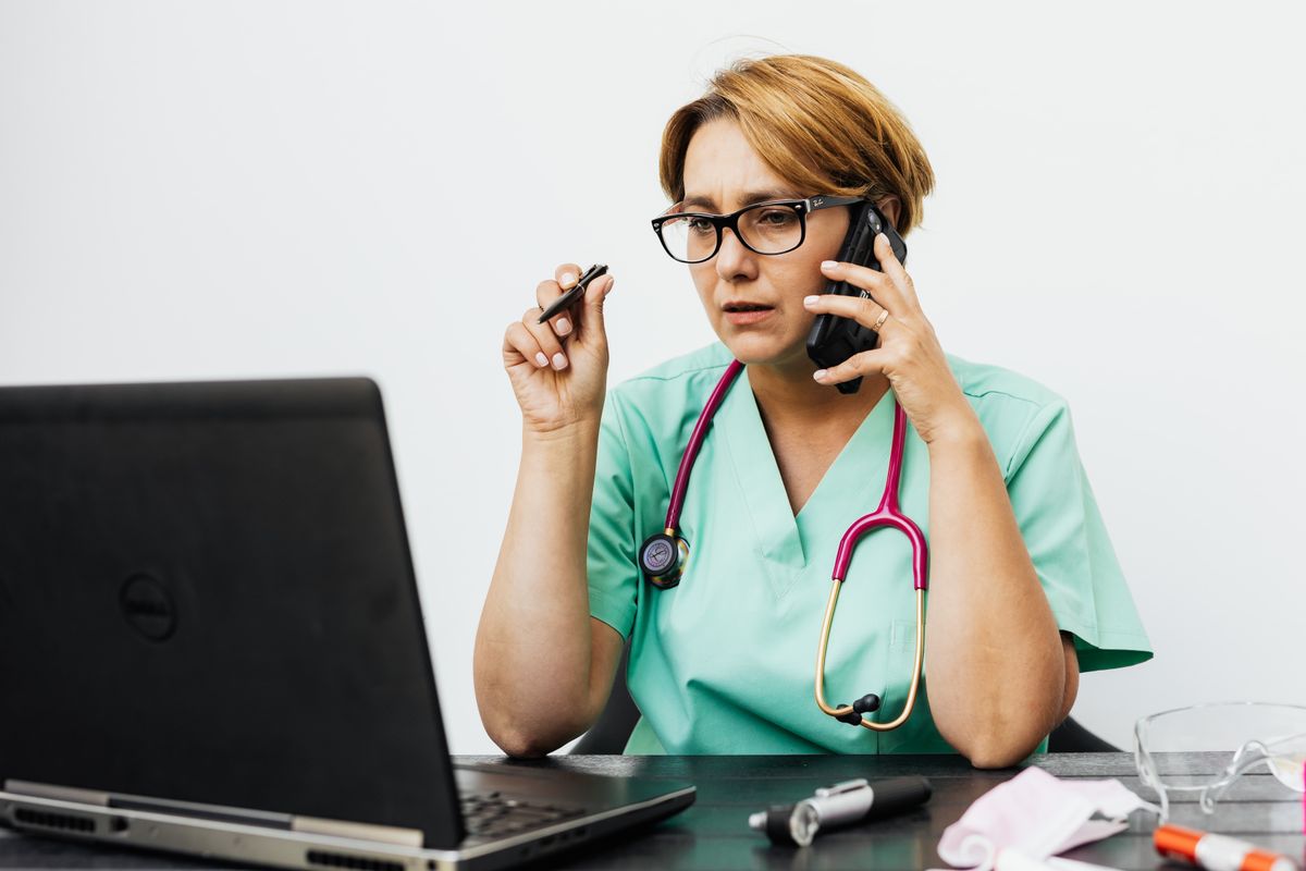 Medica trabalhando em laptop com tecnologia de inteligencia artificial no consultorio