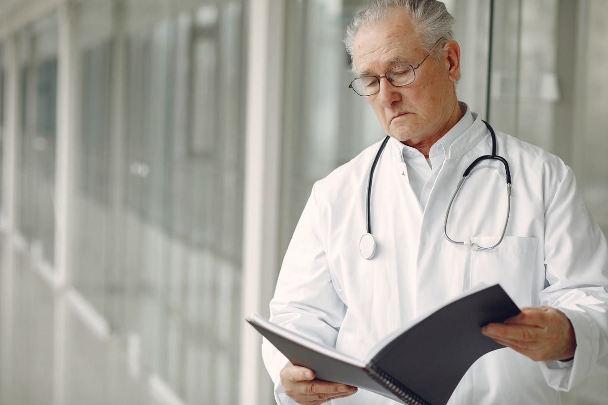 Medico lendo prontuario clinico em computador, ilustrando a revisao de documentos gerados por IA