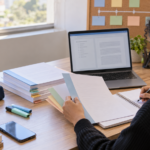 Estudante organizando a estrutura de um TCC com capítulos, anotações e notebook